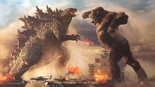 Godzilla and King Kong do battle on the deck of a giant aircraft carrier at sea against a cloudy sky with explosions all around.