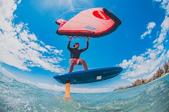 GoPro view of a wing foiler with a bright red sail against the sky