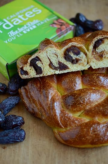 A loaf of challah, filled with apple butter and dates, sliced to show the goodness inside.