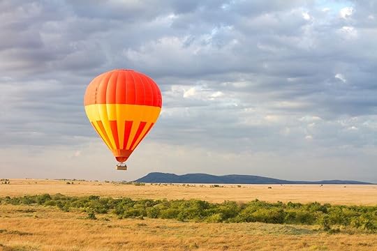 Orange hot air balloon above the Kenyan savannah