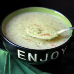 bowl of soup with spoon of vegetables.
