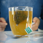 glass mug of medicine ball tea with steam rising.