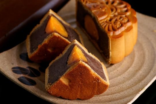 Chinese Bakeries Mooncake and tea on wooden plate for the chinese Mid Autumn festival, on black background