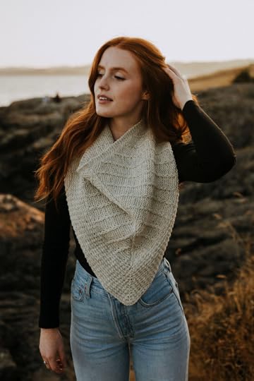 Red haired woman standing wearing knit cowl.