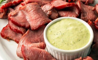 Closeup of sliced, smoked venison backstrap on a platter