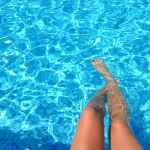 person feet dipping on pool
