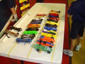 A display of pinewood derby cars at a boy scout activity