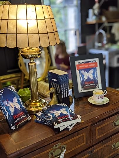 Books titled Haints displayed around a vintage lamp.