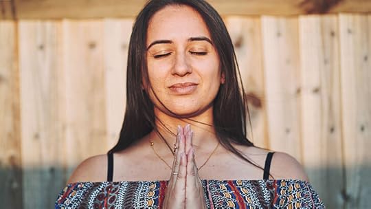 young woman meditating outside in soft sunlight