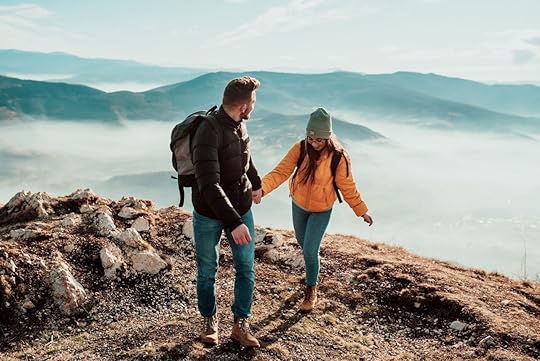 happy couple man and woman tourist at top of mountain during a hike in summer
