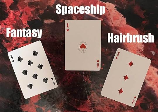 Photo of three playing cards on a red marbled color background. The cards are the eight of clubs, over which is the word 
