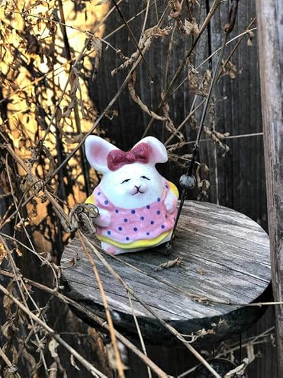 Squat white bunny in polka-dot dress