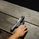person holding black semi automatic pistol