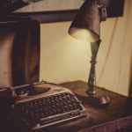 sephia photography of desk lamp lightened the gray typewriter on wooden table