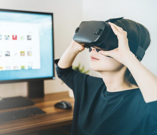 woman-with-virtual-reality-glasses-behind-computer-screen
