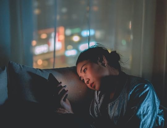 Woman alone on her phone in the dark