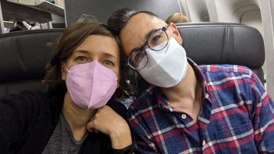 The author and Rand taking a selfie on a plane; both of them are wearing masks. 
