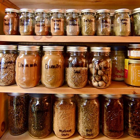 Image of wooden shelves lined with Ball® Mini Storage Jars filled with spices and dried herbs.