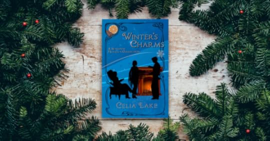 A copy of Winter's Charms, sitting on a wooden table with evergreen boughs and red berries surrounding it. The cover has three people (two standing, one sitting) around a hearthfire with seasonal decorations.