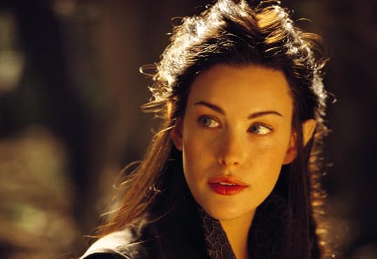 Close-up photo of a woman with long brown hair, turning back to her left