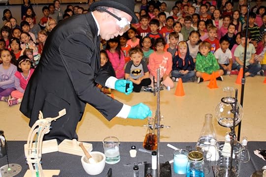 Daniel does a chemistry experiment in front of fascinated elementary school children.