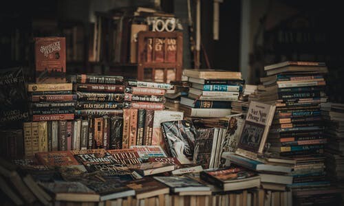An assortment of different types of books laying in a pile.