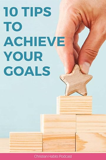 hands placing a wooden star block on top of a stack of blocks | how to achieve your goals
