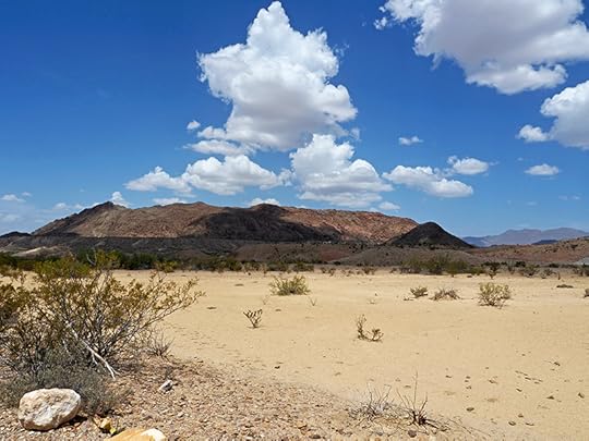 The often fruitless search for water near Big Bend. Photos show dry creek beds in a sandy, barren landscape with scrub bushes and not much else growing. But the sky is a deep blue and the clouds are huge and white.