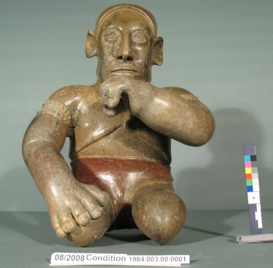 A small stone carving of a kneeling man, with one hand at his knee and the other at his chin.