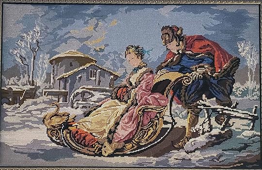 tapestry showing a winter scene of a man pushing a woman on a sleigh