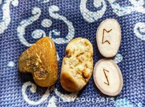 Reindeer antler runes Eihwaz and Perthro with Baltic amber rune stones Sowilo and Nauthiz on a dark blue background with white snowflakes.