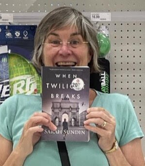 Michelle Ule holding up a copy of Sarah Sundin's When Twilight Breaks, part of 2021 reflections on books
