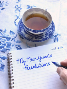 journal showing blue writing, teacup