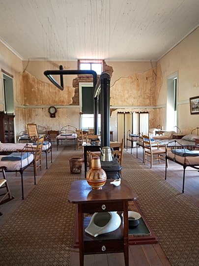 Photograph showing furnished hospital interior display at Fort Davis. The surgeon general required each patient to have 1200 ft.³ of fresh air for optimal wellness and recovery, and so the hospital had massively high ceilings.
