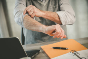 Person at a desk rolling up their sleeves