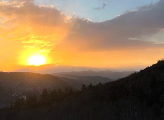 Glorious orange sunrise over a rolling range of mountains.