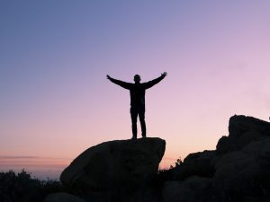 man learns how to be successful in life using keys to success on a mountain