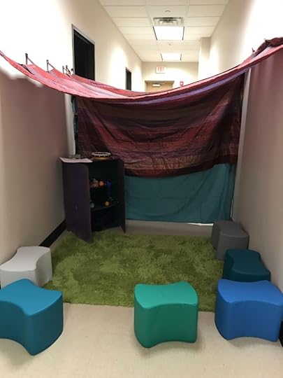 the set up: tent of pinned up curtains across the hallway, small rug and foam seats from the classroom