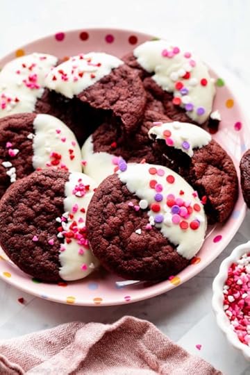 red velvet cookies dipped in white chocolate with Valentine's Day heart sprinkles on top