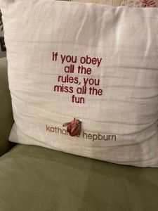 A couch pillow that has a life message printed on it.