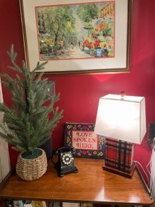 A side table with greens and lighted lamp.