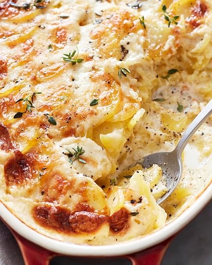 Herb topped Dauphinoise potatoes close up with spoon for ladling