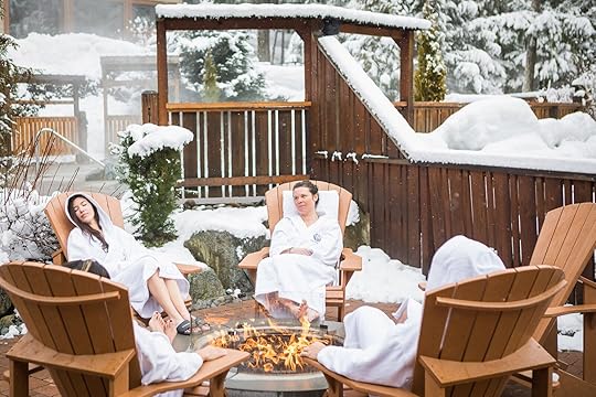 people in robes sitting around a fire pit 