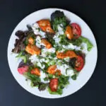 chopped cilantro and green onions topped on the dressing on the salad.