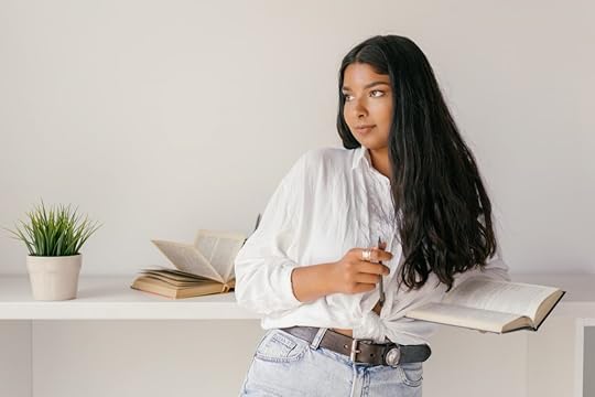 a girl is standing with a book in her hands