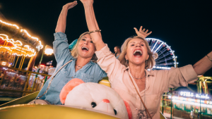 An image of two middle aged women having fun on a roller coaster ride of their lives.