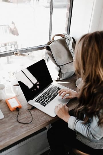 woman typing on a laptop in a cafe.