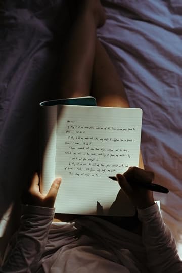 Crop lady with pen and notebook on bed at home