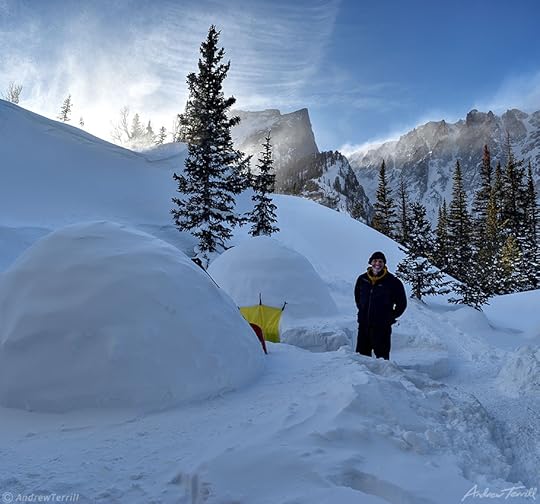 andrew terrill outside igloos with wind and spindrift swirling over ridge