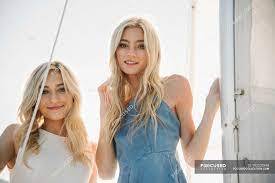 Two blonde teenage girls relaxing on sailboat. — looking in camera, young adult women - Stock Photo | #192203348